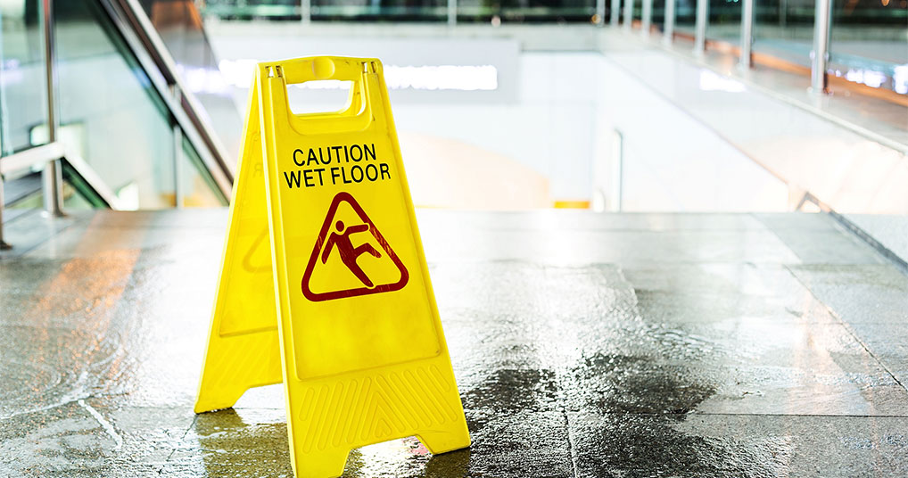 Wet floor with "caution wet floor" signage